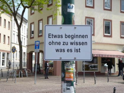 Schild mit folgender Anweisung: Etwas beginnen ohne zu wissen was es ist.