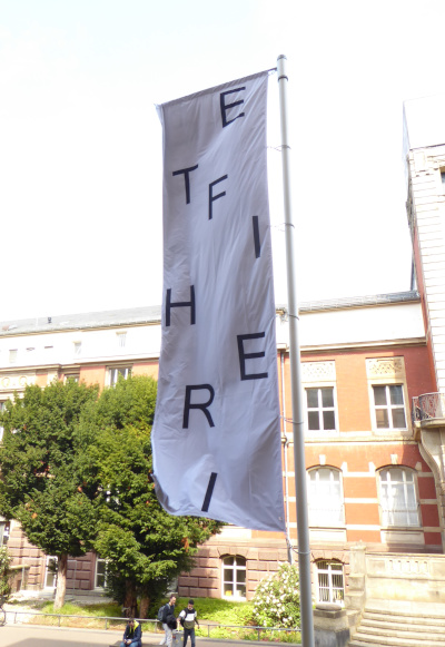 Auf einer Fahne sind locker verstreute Buchstaben zu lesen. Zusammengesetzt ergeben sie das Wort Freiheit.